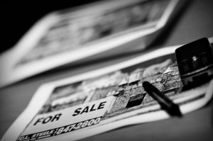 Black and white photo of a paper that says "For Sale".